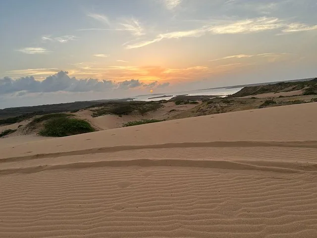 Sunset view over rolling sand dunes leading down to the ocean